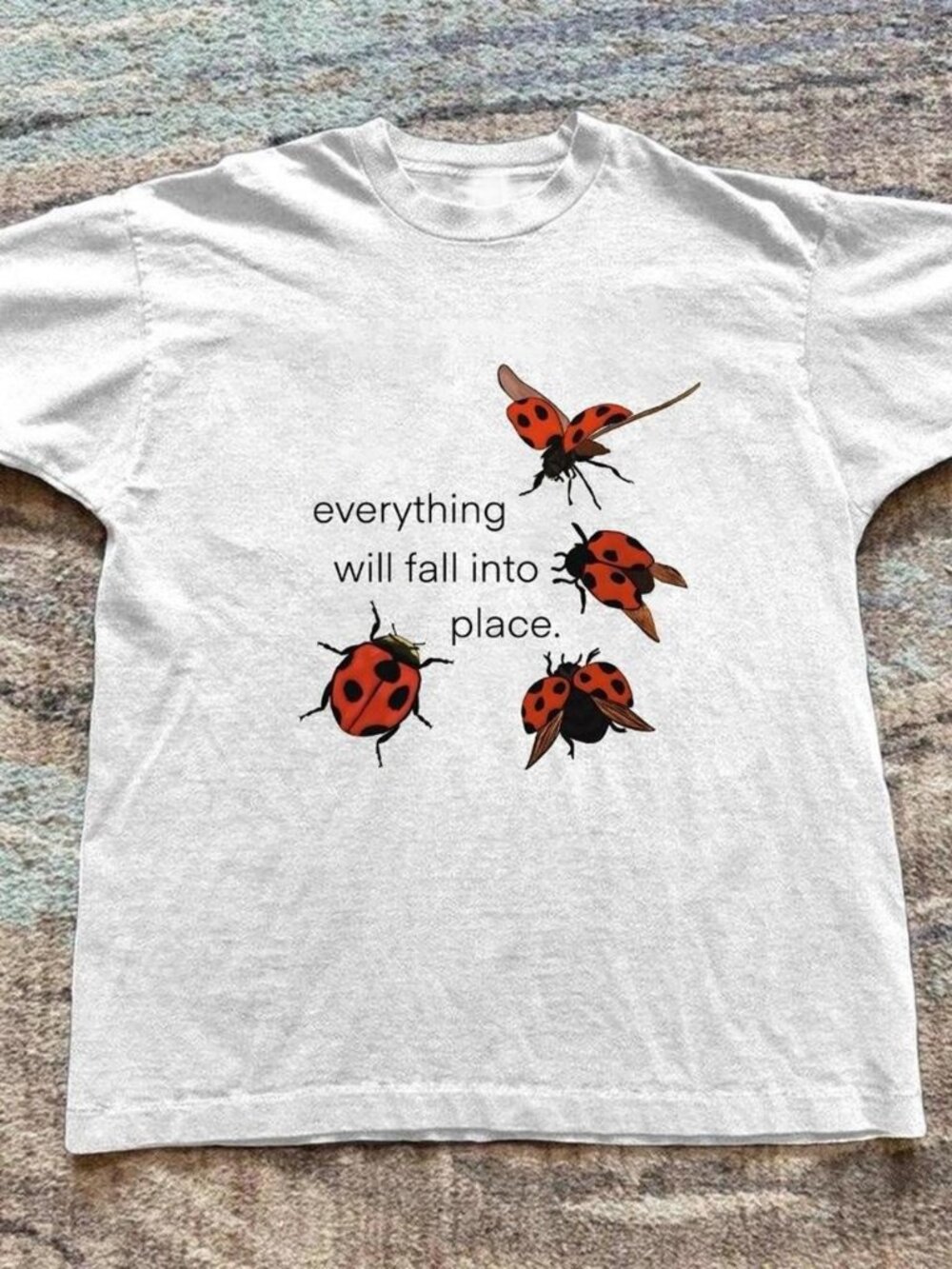 White graphic t-shirt a ladybug  "everything will fall into place" t-shirt
